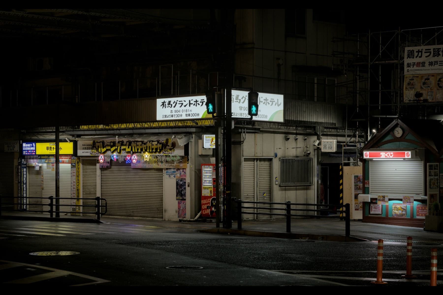 Shuttered shopfronts on a wet street at night